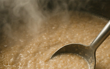 Steamy cereal mash in a brew kettle—used to gelatinize grains like corn or rice before all-grain brewing.