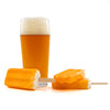 Glass of Cream Ale with two orange popsicles on a white background