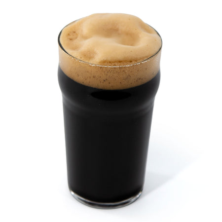 Dark beer with a thick head in a glass on a white background