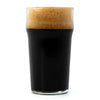 Glass of dark beer with a thick head on a white background