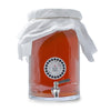 Kombucha Brewing in a glass fermenter with a stainless steel spigot, muslin cover, and adhesive thermometer attached