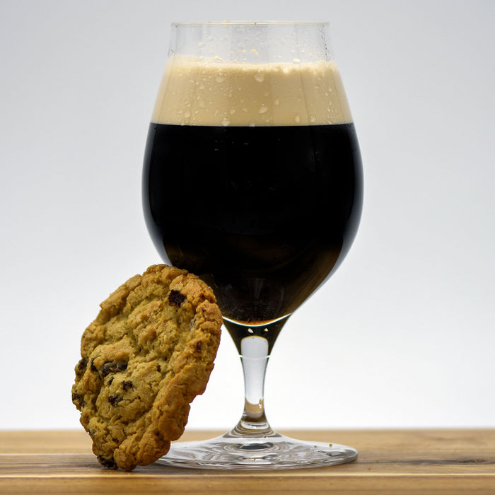 Oatmeal Cookie Pastry Stout in a glass with an oatmeal cookie leaning against it