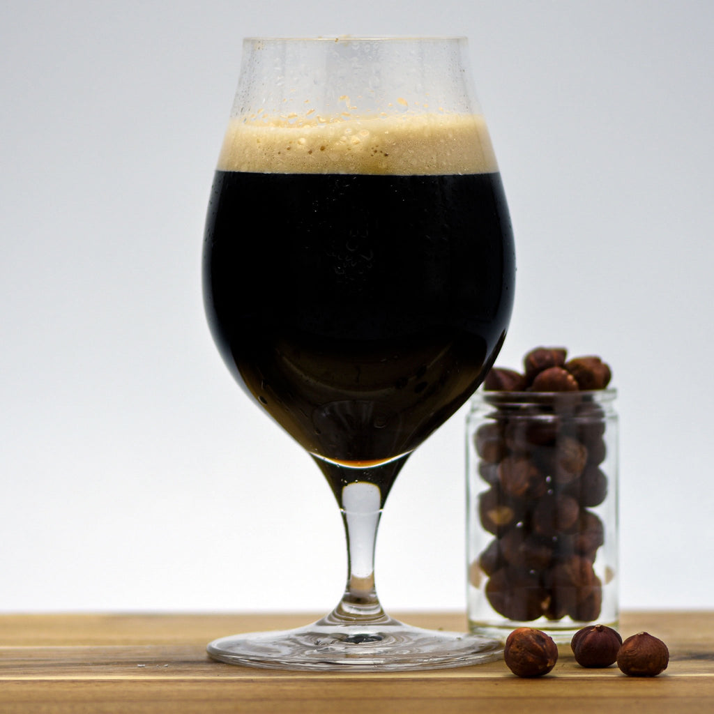 Hazelnut Pastry Stout with a glass filled with hazelnuts adjacent
