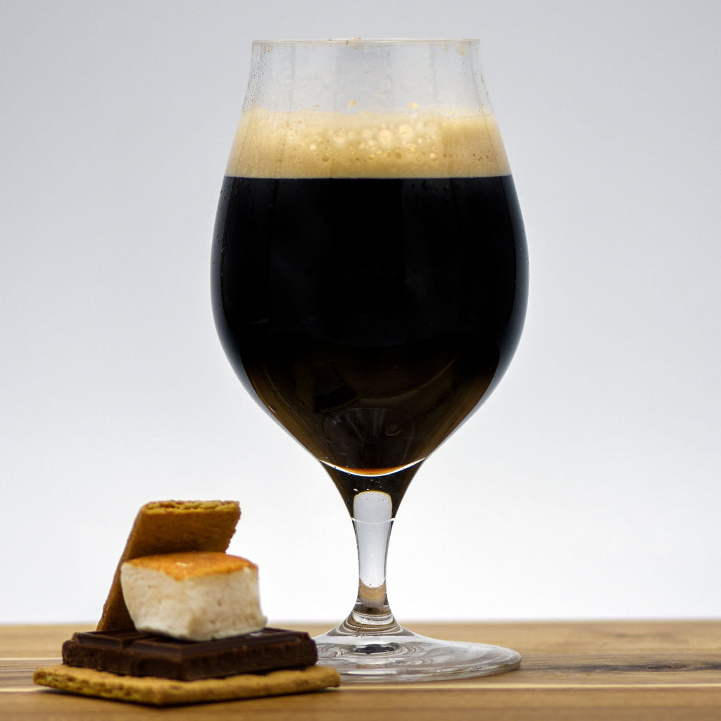A glass of Smore's Pastry Stout with a Smores beside it