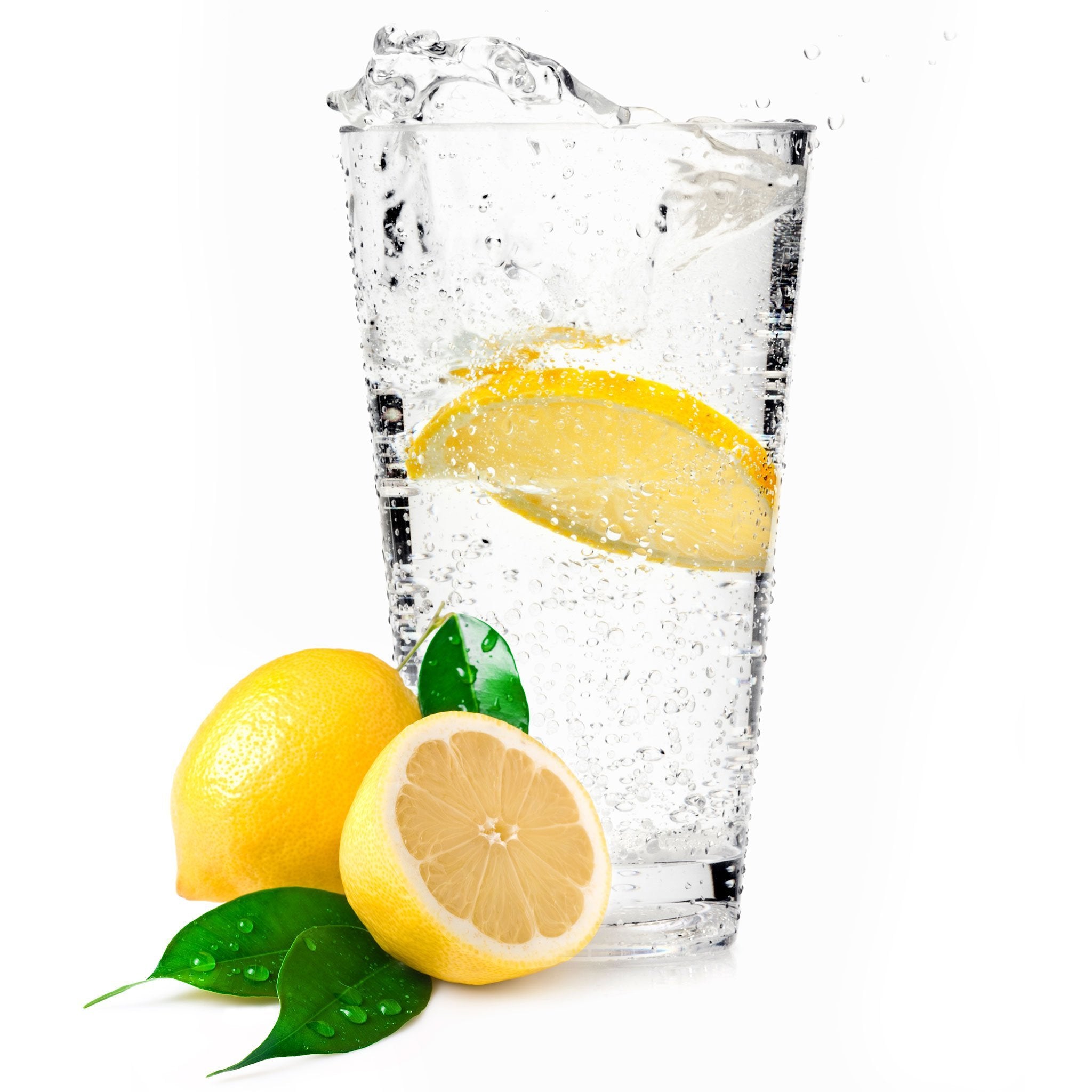 A glass full of Lemon Hard Seltzer with a lemon wedge next to the glass.