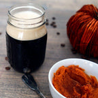 Pumpkin Spice Latte Stout in a mason jar beside a bowl of pumpkin and some pumpkin bread