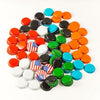 A pile of orange, blue, black, green, red, white, and american flag colored Fermenter's Favorites Crown Beer Bottle Caps